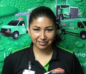 Brown-eyed, dark haired lady with hair tied back wearing collared SERVPRO uniform shirt