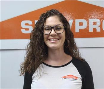 Female crew member standing in front of logo