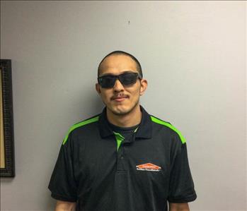 SERVPRO employee in front of gray wall