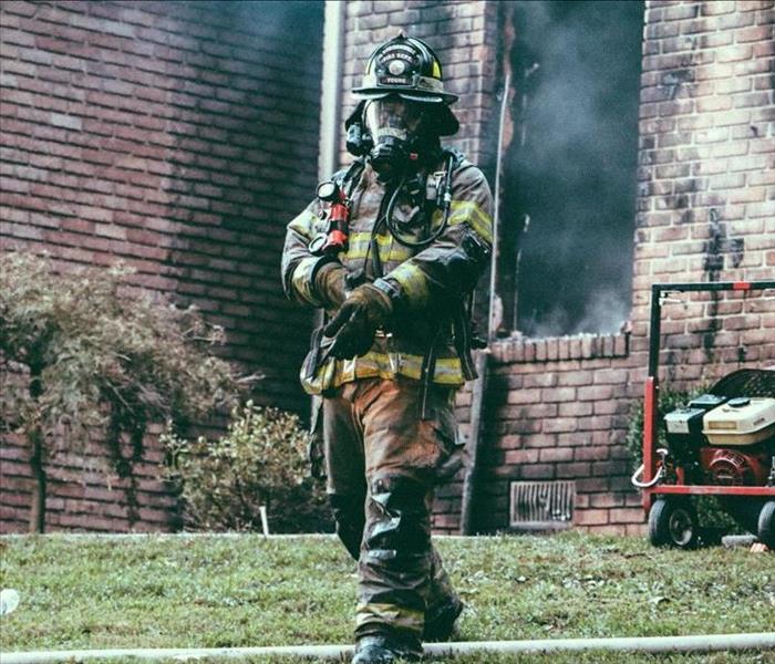 Fireman in front of house