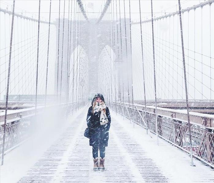 Woman walking on snow covered bridge