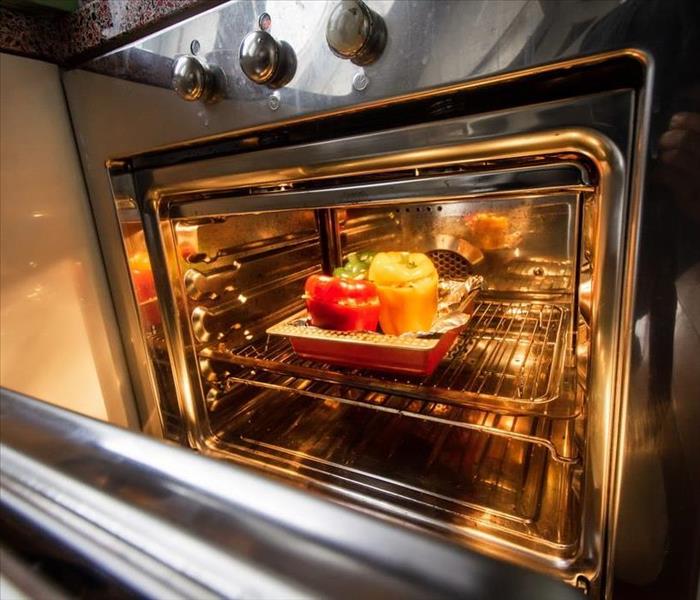 stainless steel oven with stuffed bell peppers inside