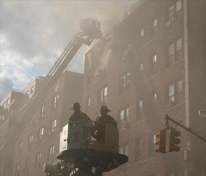 firefighters in front of burning building 