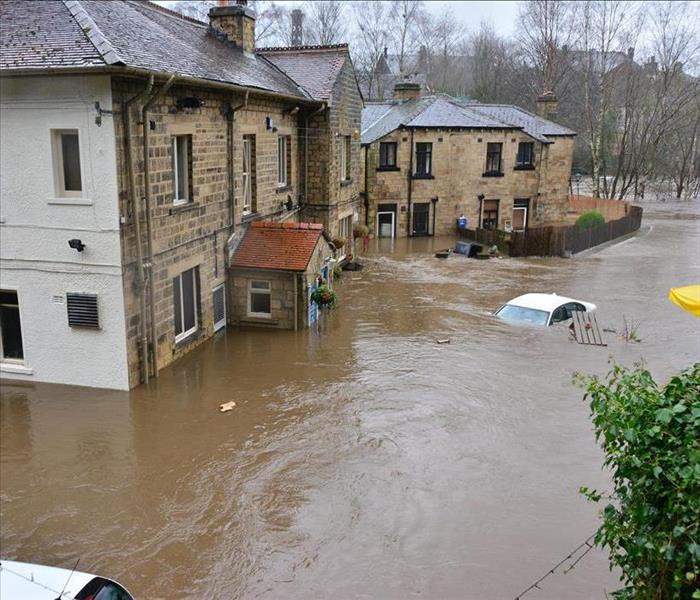 flooded residential area with water over the hoods of cars